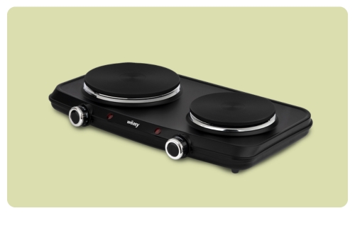 Black double electric hotplate cooker with two round cast-iron burners and front control knobs on pale green background