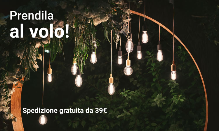 Warm hanging Edison bulbs on a wooden circular arch with trailing greenery, outdoor decorative event lighting at night