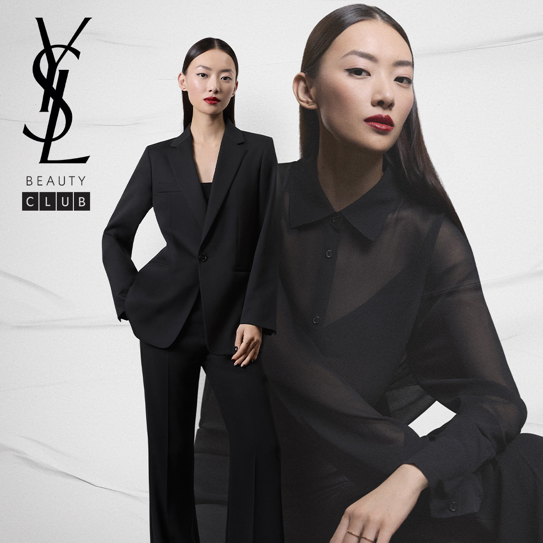 Una donna sofisticata che indossa un tailleur nero e un rossetto rosso audace, con il logo YSL Beauty Club.
