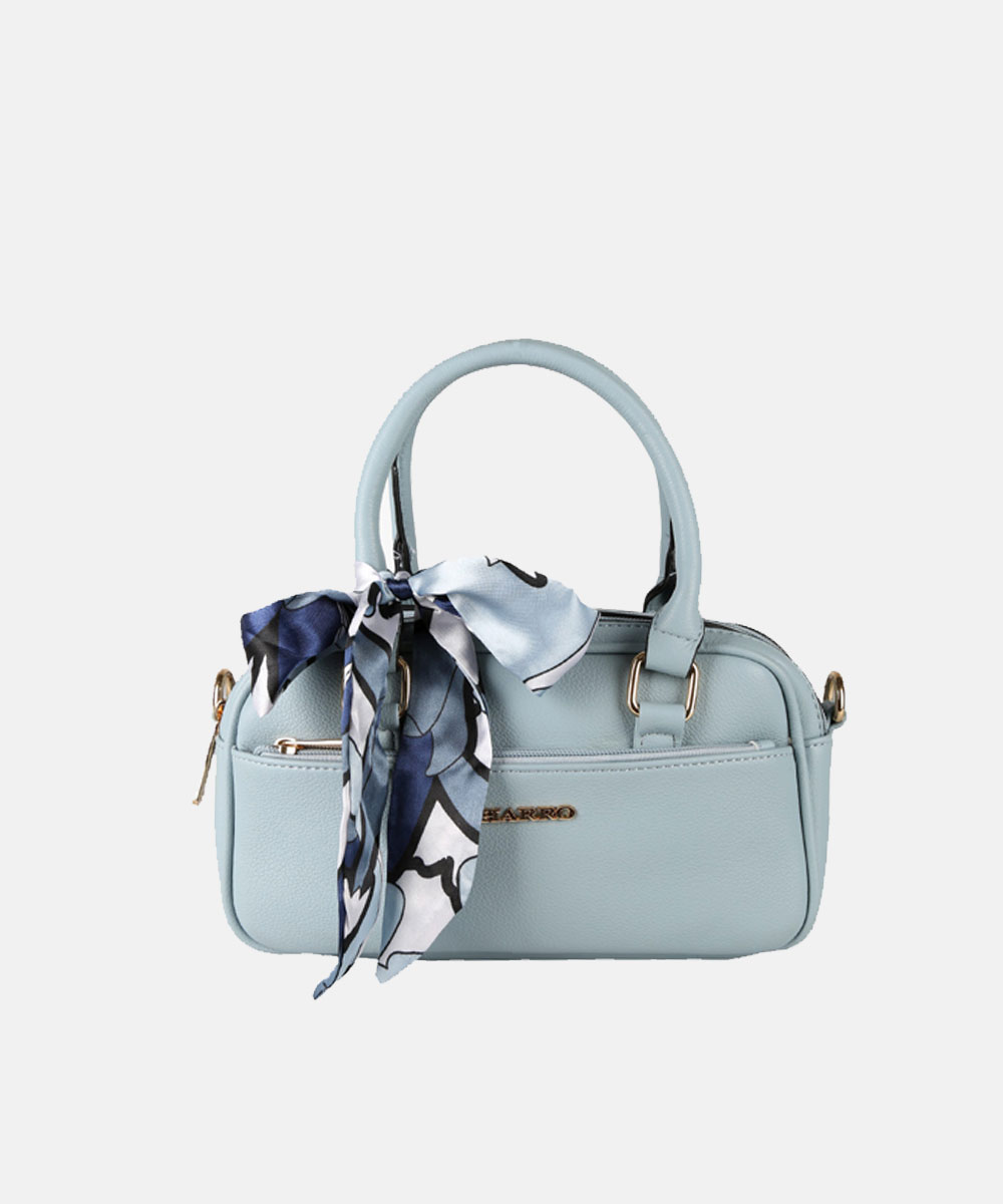 Light blue leather handbag with top handles, gold hardware, front zip pocket and a tied blue patterned silk scarf