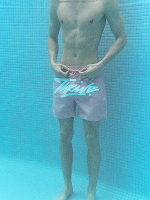 Modello con pantaloncini da bagno rosa sott’acqua.