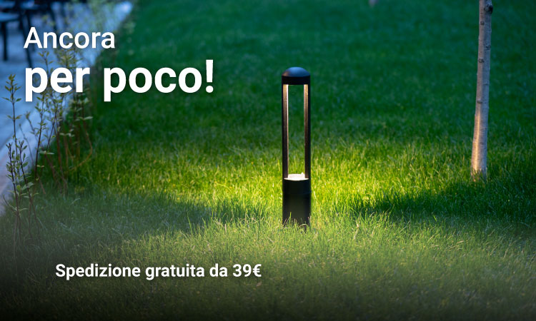 Illuminated outdoor bollard lamp on a green lawn at dusk, promotional Italian text offering free shipping from €39
