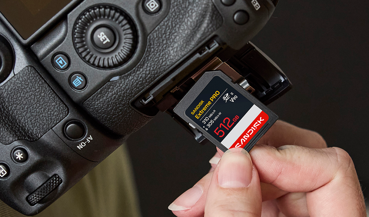 Una mano che inserisce una scheda SD SanDisk Extreme Pro da 512 GB in una fotocamera.