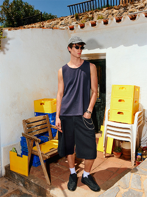 Modello con canotta, shorts lunghi e cappello.