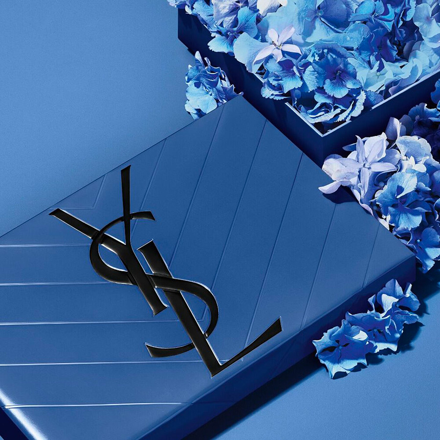 Un sofisticato set regalo YSL BEAUTY caratterizzato da un raffinato motivo floreale blu e dall'iconico logo YSL, che rappresenta l'arte del regalo di lusso.