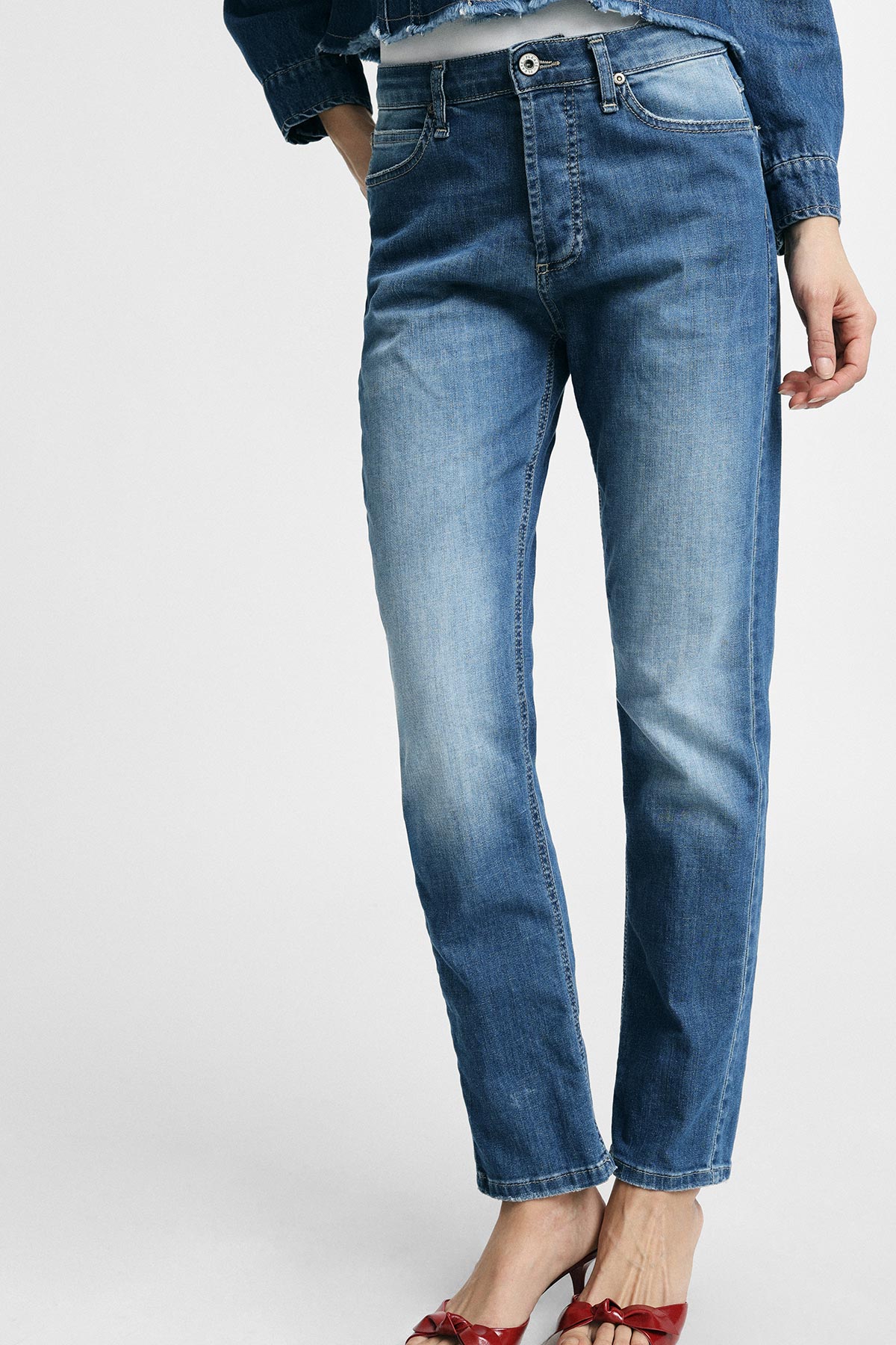 Women's mid-rise straight-leg blue denim jeans with faded wash, model wearing red slingback heels and a cropped denim jacket