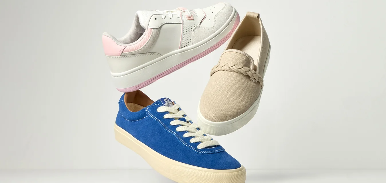 Tre scarpe fluttuanti: sneaker bianche e rosa, mocassino beige con dettaglio intrecciato e sneaker blu con lacci e suola crema, su sfondo chiaro.