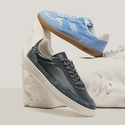Due sneakers, una nera e una blu, esposte su e sopra una testa di scultura classica bianca contro uno sfondo neutro.