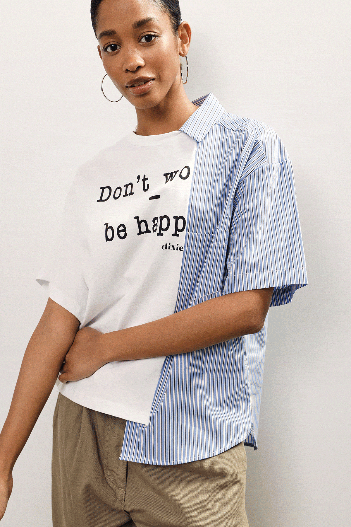 Three women modelling casual tops: slogan tee with striped overshirt; white embroidered v‑neck; pink‑brown colour‑block tee with clutch