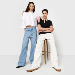Due modelli stanno uno accanto all'altro. Uno indossa una maglietta corta bianca e jeans ampi blu; l'altro indossa un polo nera e pantaloni bianchi.