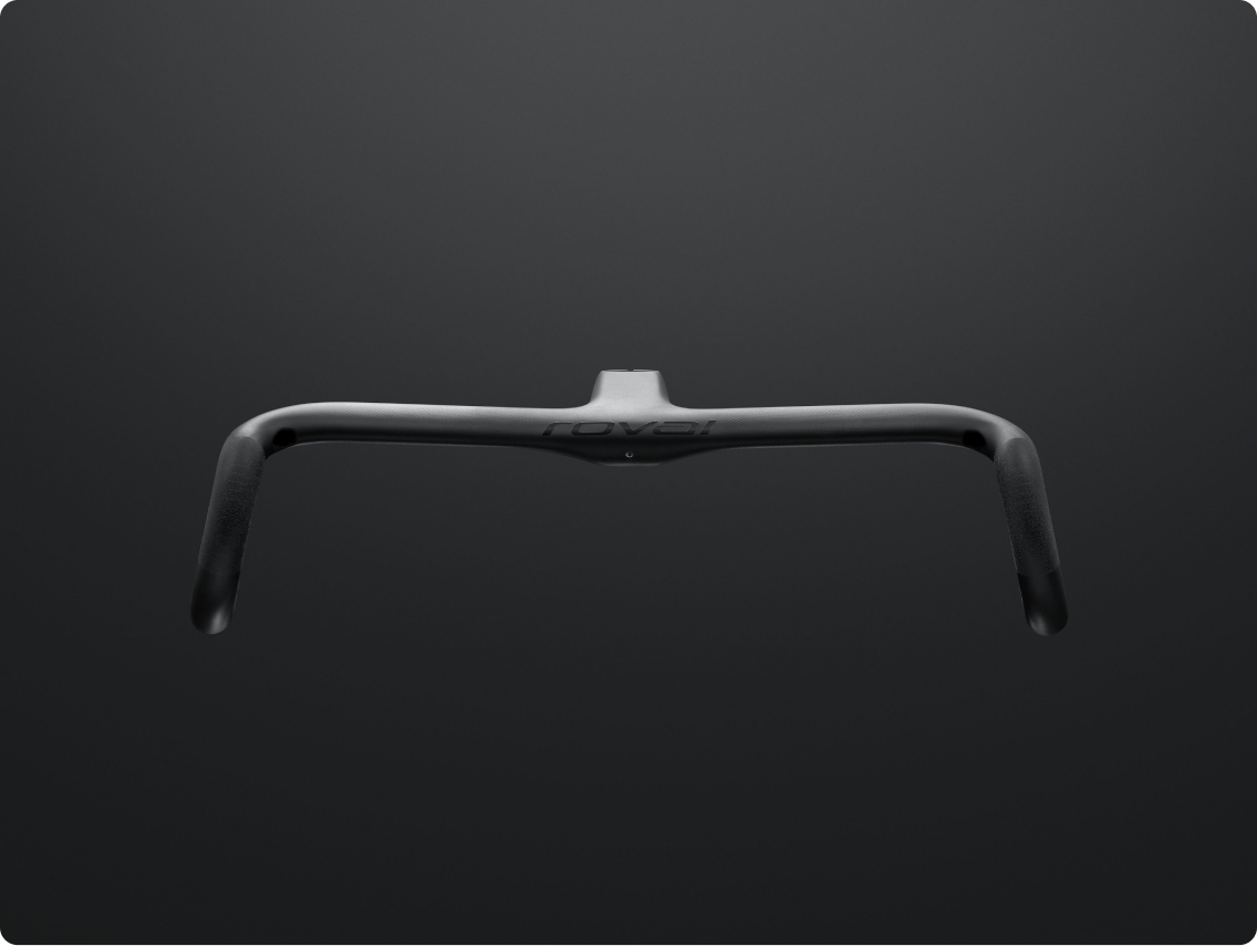Matte black integrated carbon road bike handlebar with ergonomic drops and integrated stem on dark background