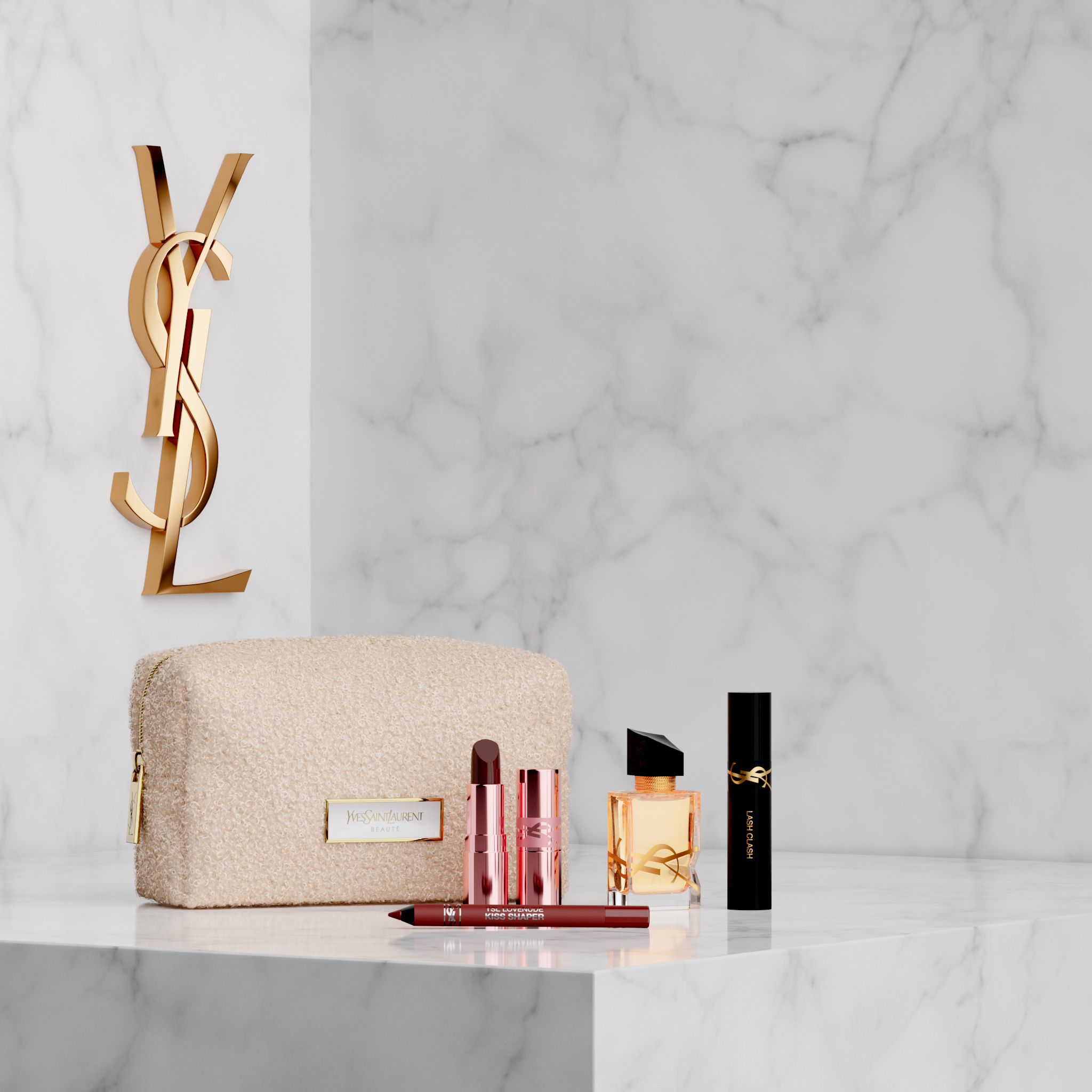 Trucco YSL e profumo Libre con una trousse beige su marmo bianco.