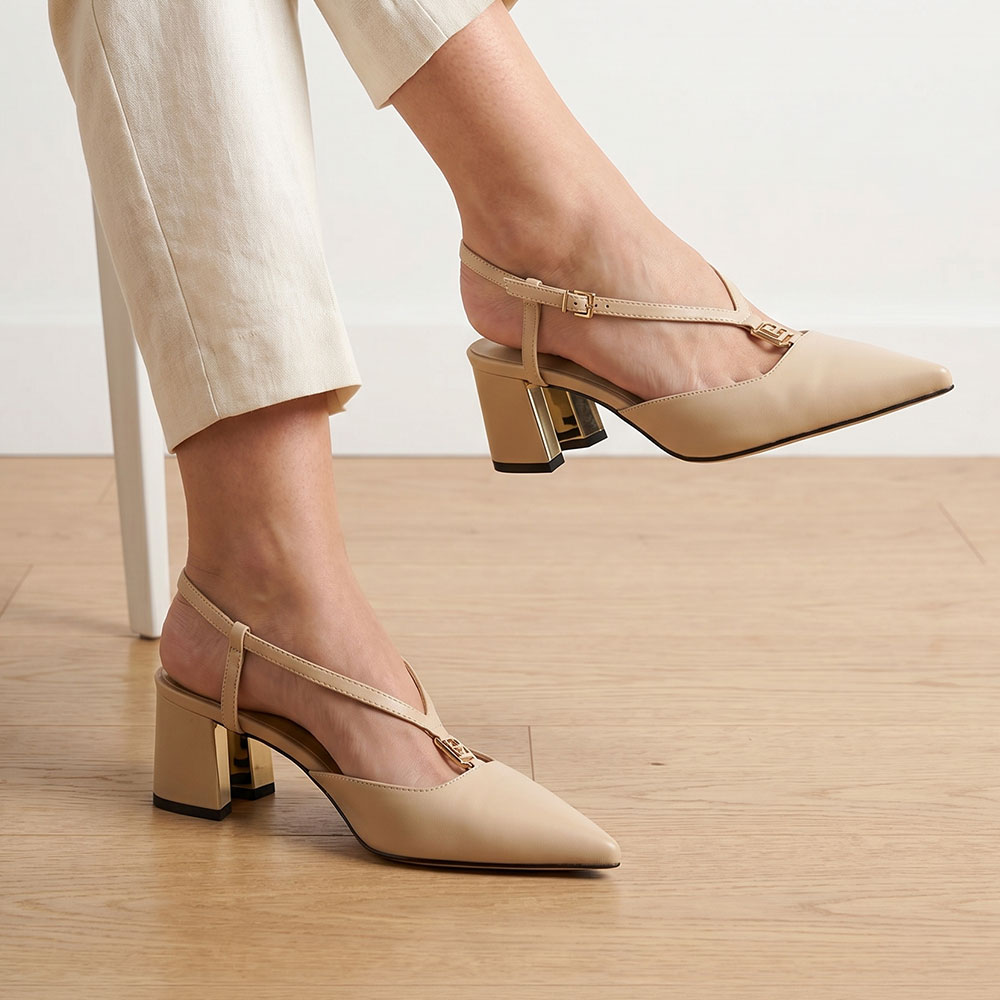 Beige pointed-toe slingback block-heel shoes with gold buckle detail, model wearing cream trousers