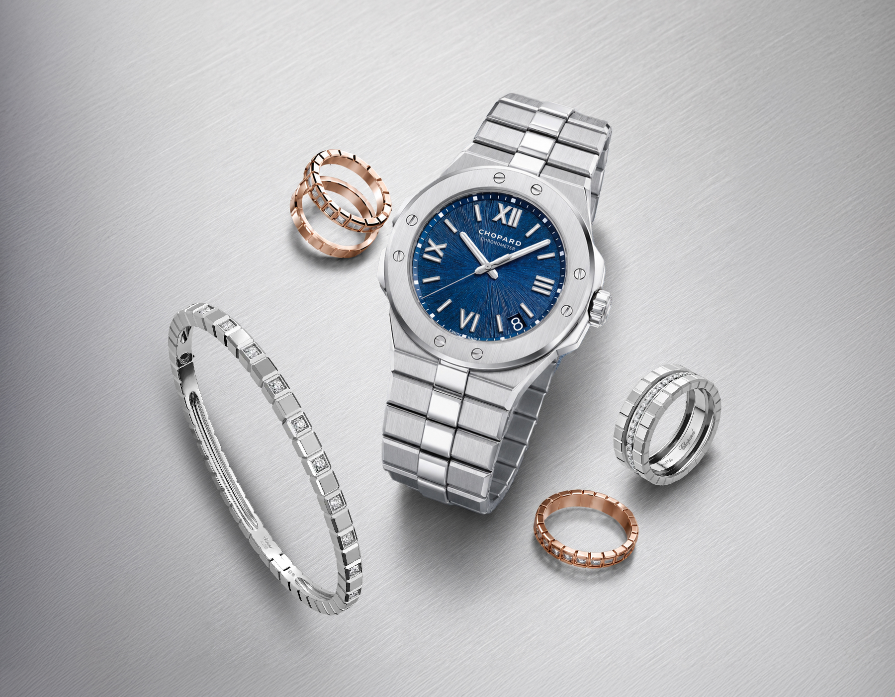 Stainless steel Chopard watch with blue textured dial and bracelet, shown with rose-gold and silver rings, diamond bracelet