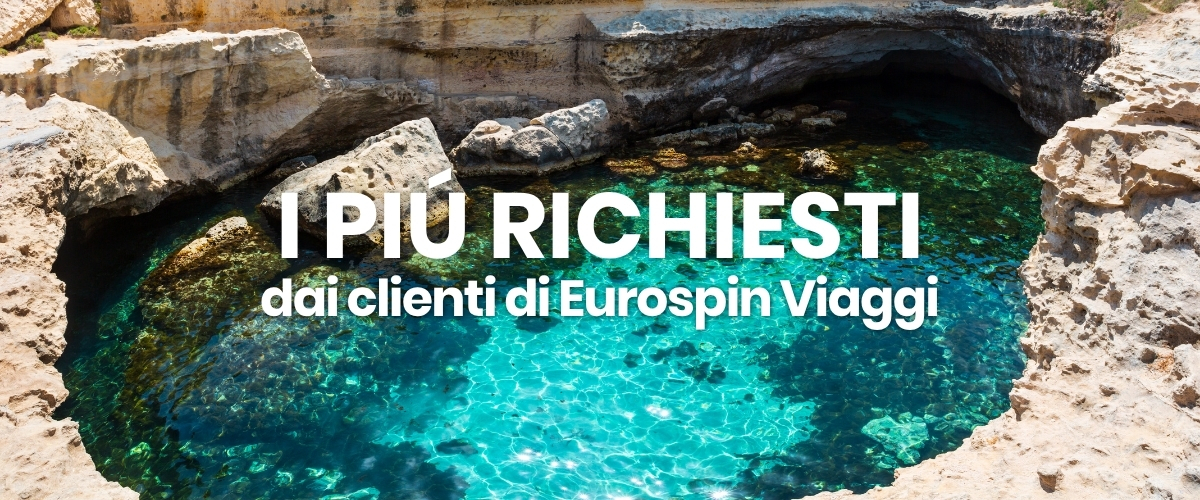Igneous rocky coastline surrounding a turquoise natural sea pool with overlay text 'I PIÙ RICHIESTI dai clienti di Eurospin Viaggi'