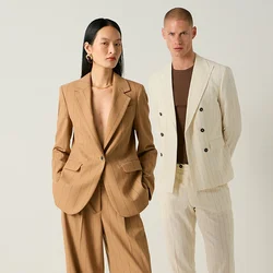 Due modelli sono in posa su uno sfondo semplice, uno con un tailleur pantalone a righe beige, l’altro con un completo crema a righe, camicia marrone e scarpe nere.