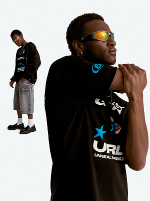 Modello con T-shirt nera stampata e shorts in denim.