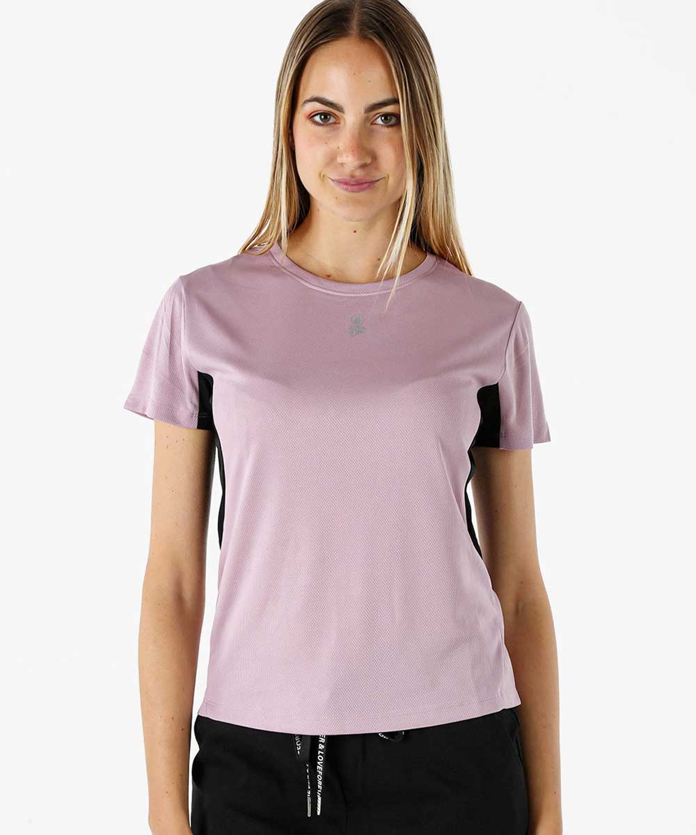 Woman modelling pale mauve short-sleeve athletic top with black side panels and black joggers, front-facing on white background