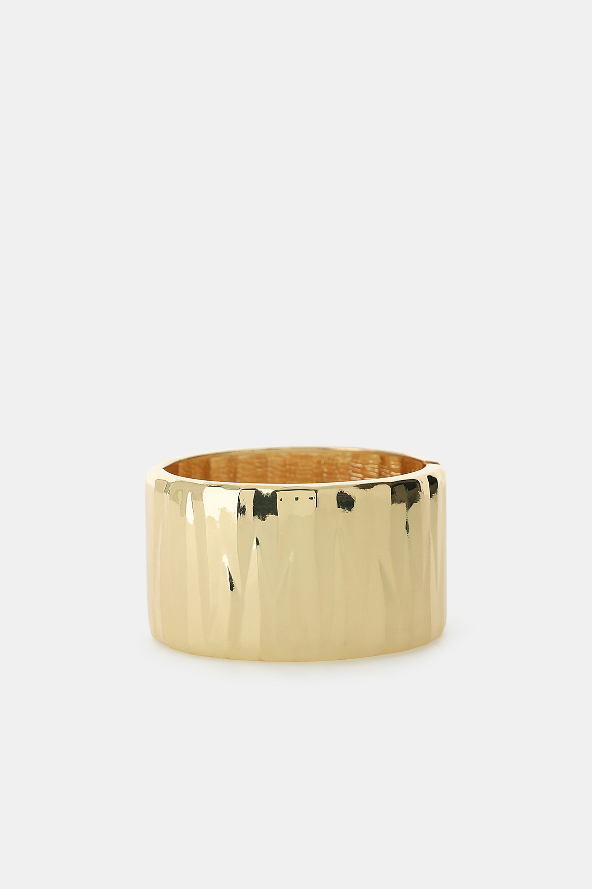 Wide hammered gold bangle bracelet on white background, polished textured finish