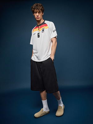 Modello con maglia da calcio del Belgio e shorts lunghi.