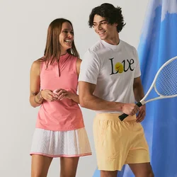 Un uomo e una donna sorridenti in abbigliamento da tennis stanno vicino a uno sfondo di tessuto blu, con l'uomo che tiene una racchetta da tennis.