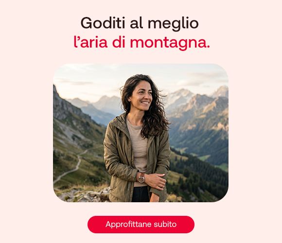 “Donna sorridente in montagna con panorama alpino sullo sfondo. Testo: ‘Goditi al meglio l’aria di montagna’ con pulsante ‘Approfittane subito’.” “Donna sorridente in montagna con panorama alpino sullo sfondo. Testo: ‘Goditi al meglio l’aria di montagna’ con pulsante ‘Approfittane subito’.”