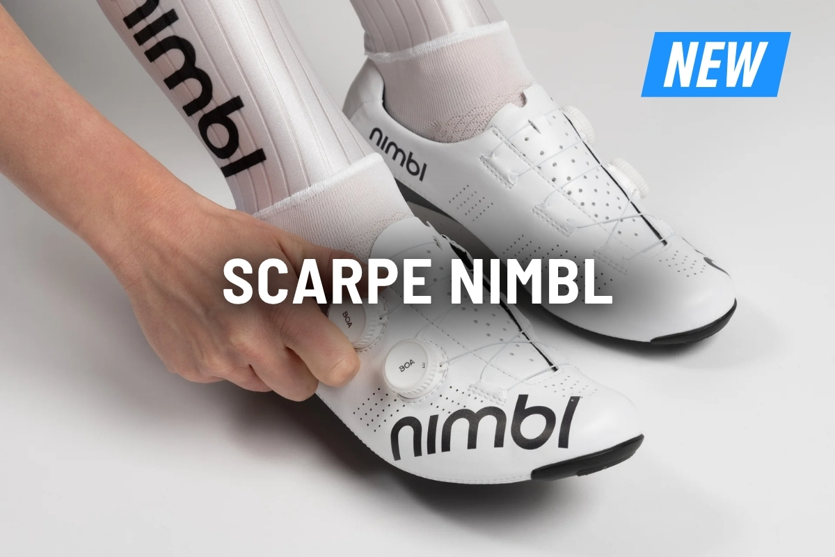 White Nimbl cycling shoes with dual BOA dials being tightened by hand, Nimbl logo and white cycling socks visible