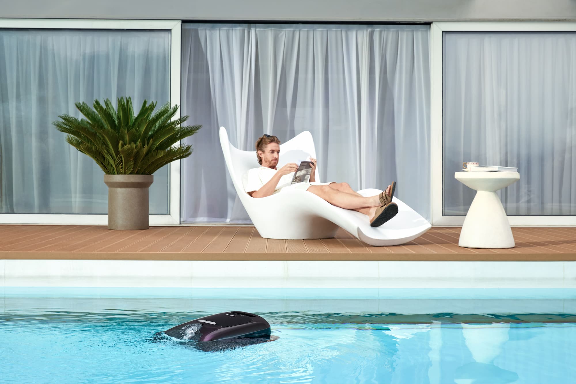 Un uomo seduto a bordo piscina, senza niente da fare