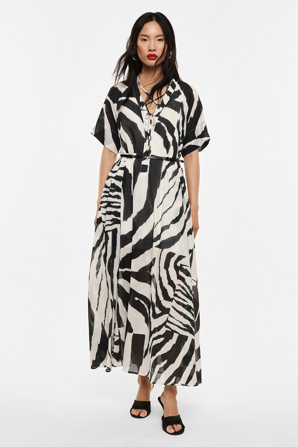 Model in black-and-white zebra print maxi dress with V-neck, tie waist and black heeled sandals