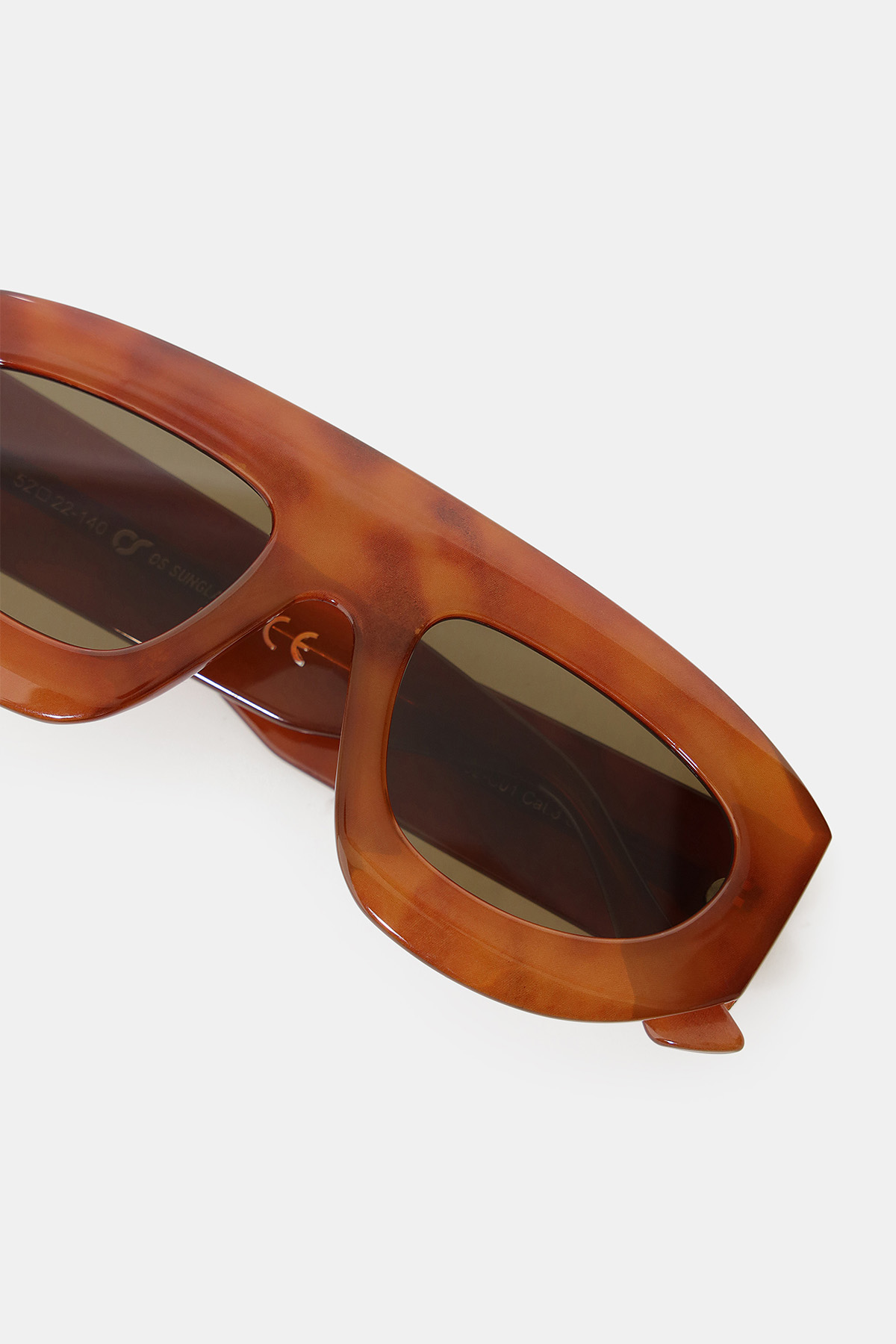 Close-up of brown tortoiseshell rectangular sunglasses with dark lenses on a white background