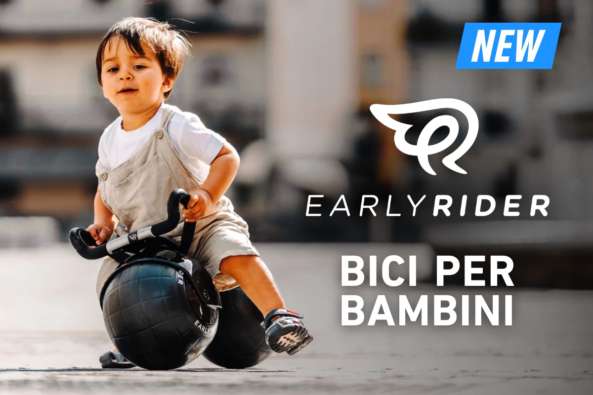Toddler riding a black Early Rider balance bike outdoors, Early Rider logo and 'Bici per Bambini' text with a 'New' badge