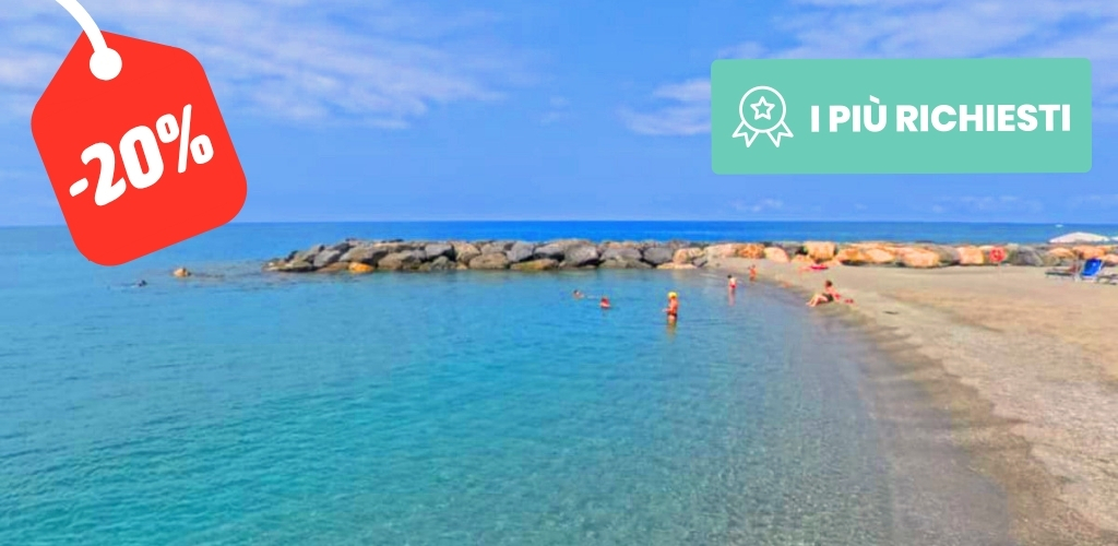 Sandy Mediterranean beach with clear turquoise water, rocky breakwater and swimmers under a -20% sale tag and 'I PIÙ RICHIESTI' badge