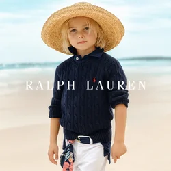 Maglione a collo alto blu navy con lavorazione a trecce, pantaloni bianchi arrotolati e un ampio cappello di paglia. Include una sciarpa a fantasia floreale legata in vita.