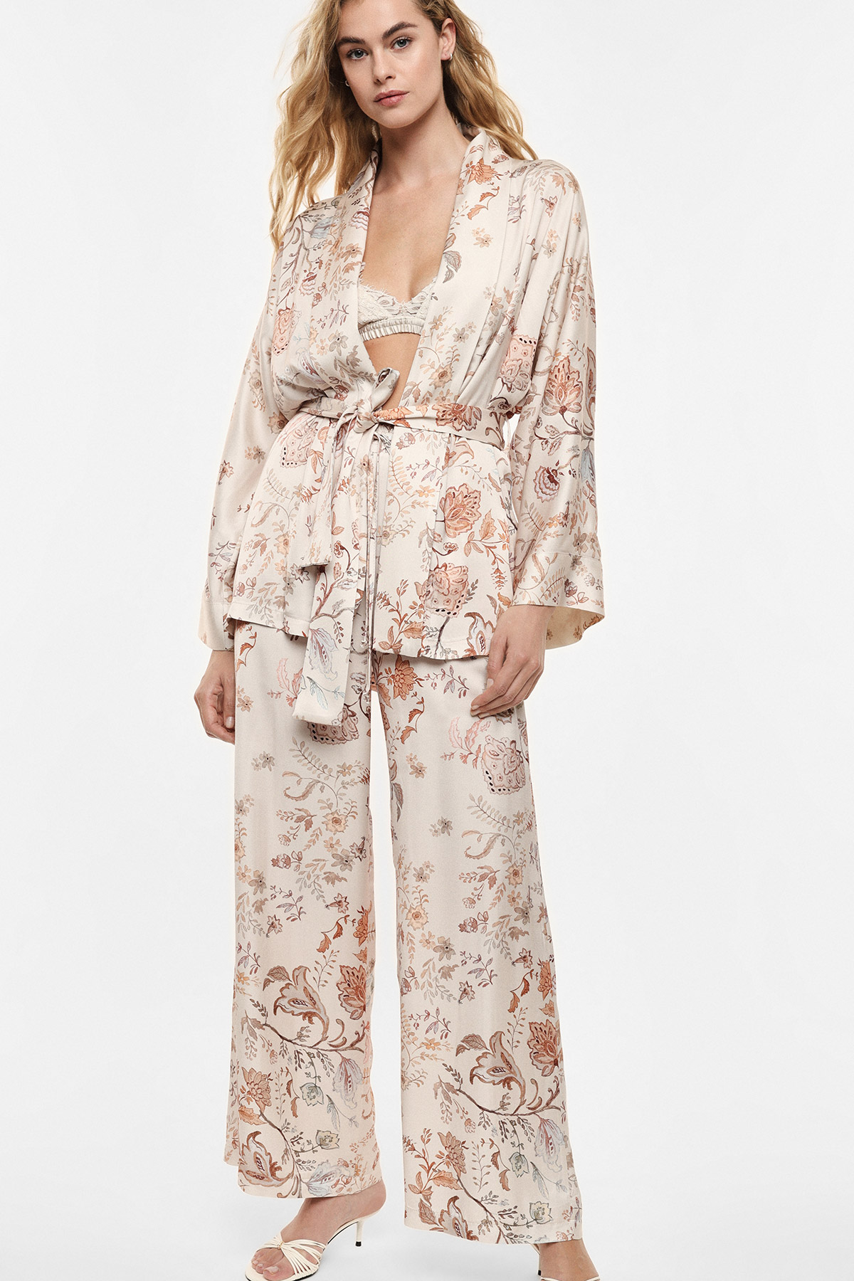 Cream-coloured floral satin kimono robe tied at the waist with matching wide-leg trousers, lace bralette and cream heels