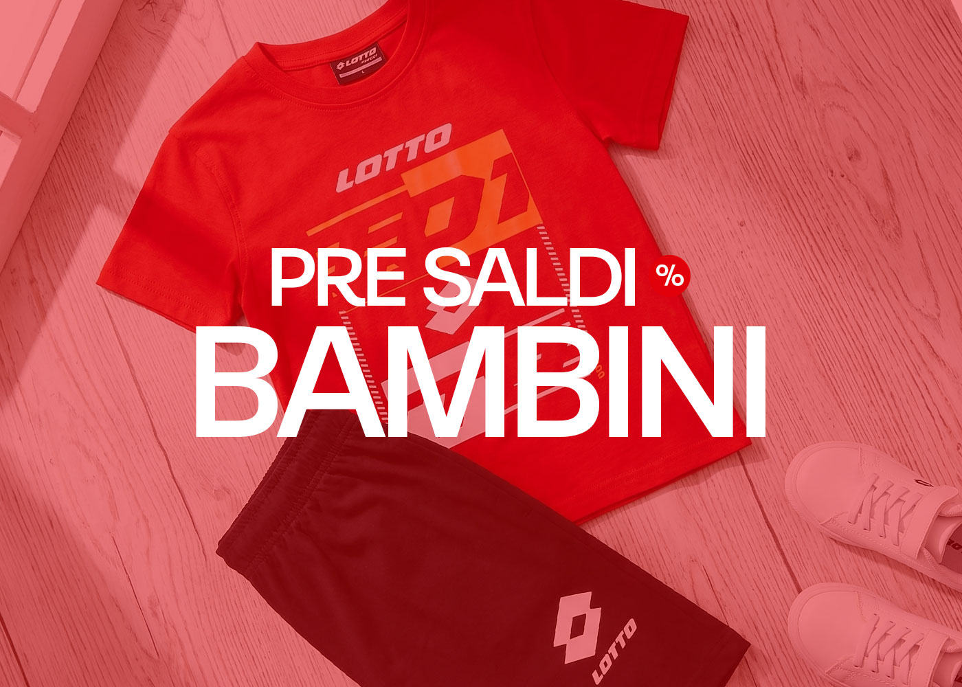 Flat-lay of children's red Lotto T-shirt, black shorts and white trainers on wooden floor — kids' sale banner