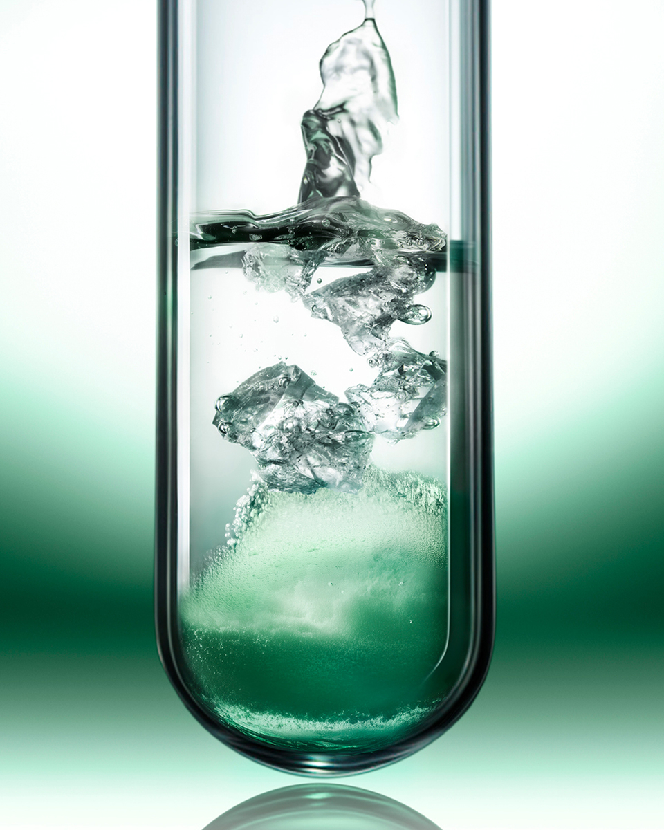 Provetta scientifica e flacone di siero appoggiato sulla sua texture fresca e leggera.