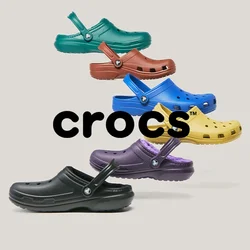 Sei colori vivaci di clogs Crocs in nero, viola, giallo, blu, rosso e verde, disposti in una formazione verticale sfalsata su uno sfondo chiaro.