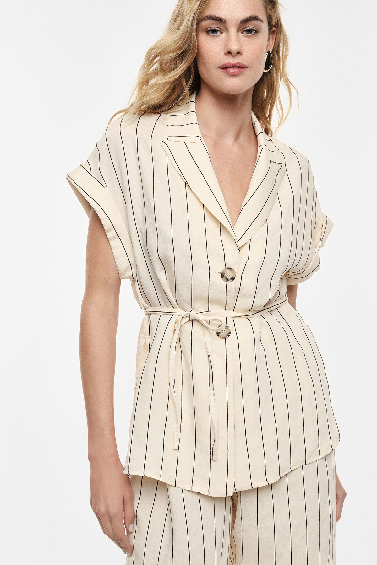 Cream pinstripe short-sleeve belted blazer and matching wide-leg trousers worn by a woman, lightweight summer suit