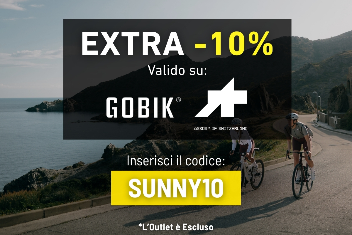 Two cyclists on a coastal road by sea and cliffs, overlay advert offering EXTRA -10% on GOBIK and ASSOS with code SUNNY10