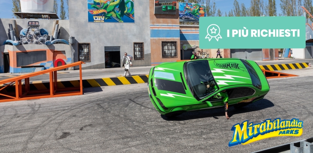 Green Hot Wheels stunt car driving on two wheels with driver leaning out during Mirabilandia Parks stunt show, stage and ramps