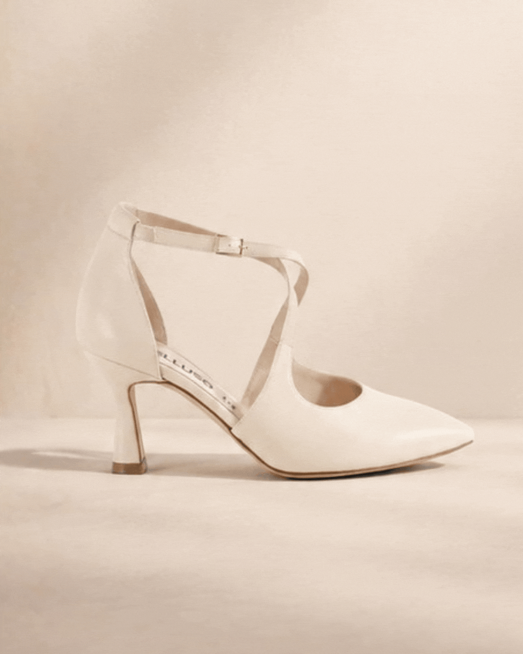 White women's strappy mid-heel pump beside black men's leather oxford dress shoe on beige background