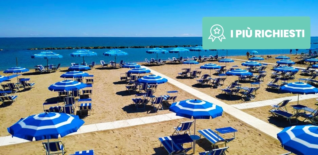 Sandy Mediterranean beach with rows of blue-and-white striped umbrellas and sunbeds, boardwalk paths, calm sea and clear sky, green promo badge