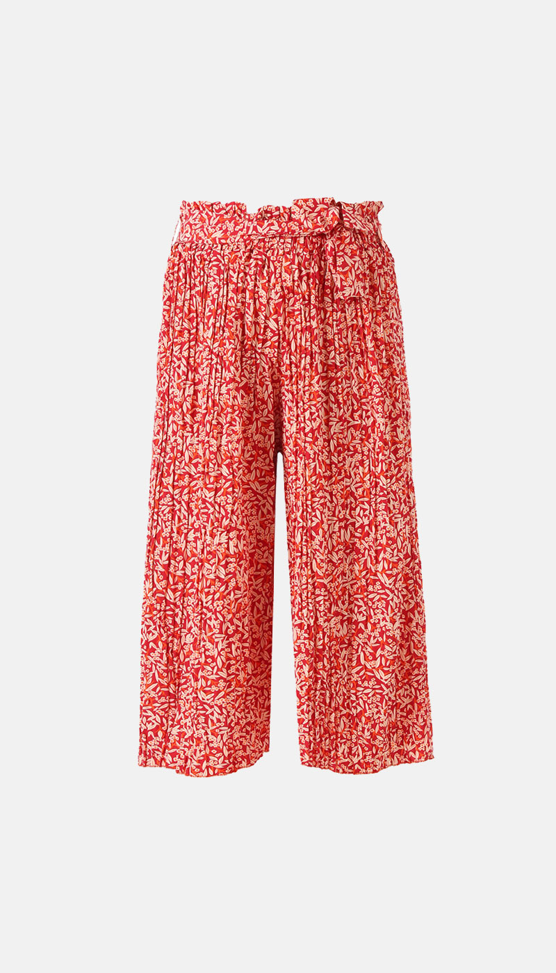 Red cropped wide-leg trousers with white floral print, paperbag waist and tied fabric belt