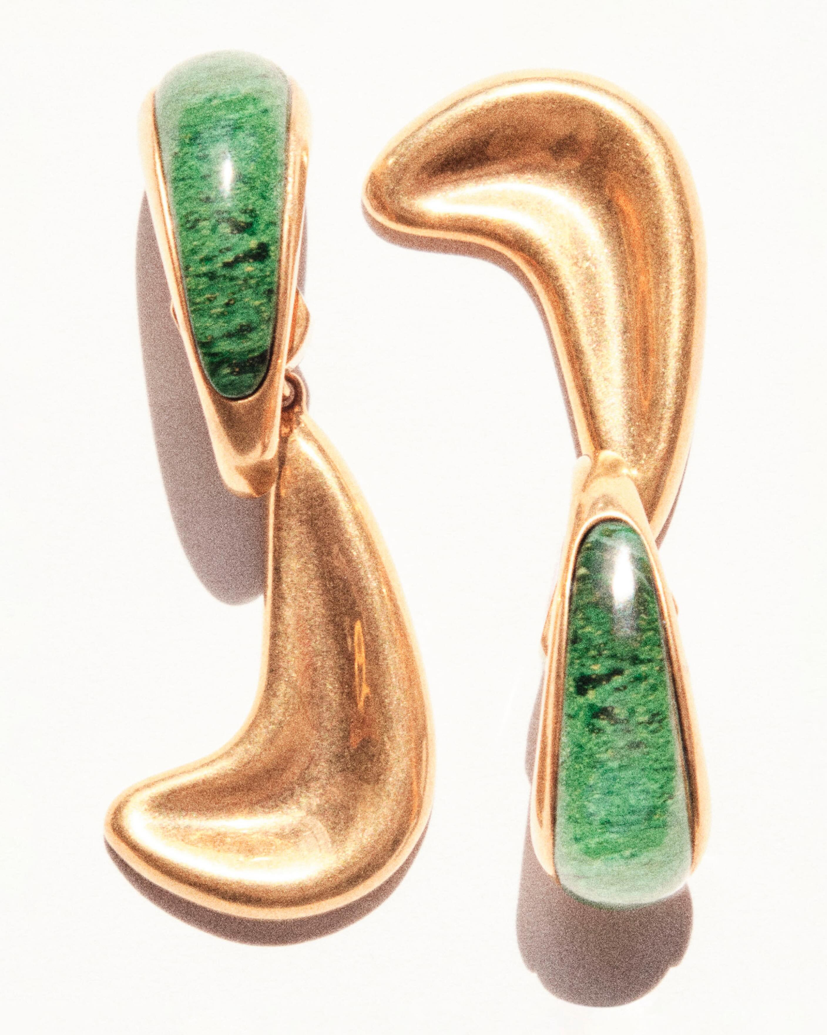 Pair of sculptural gold drop earrings with polished green malachite insets on a white background