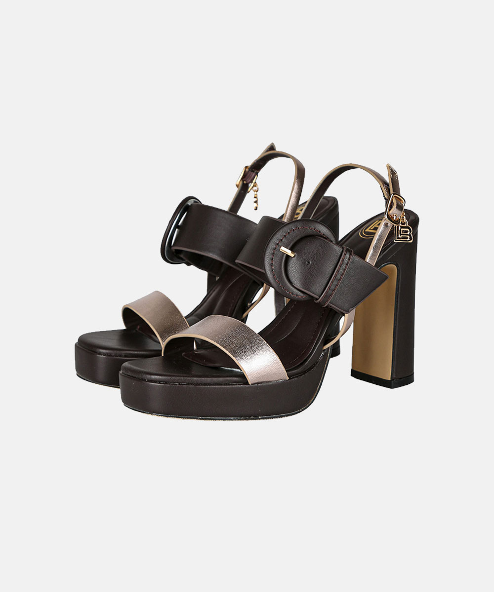 Pair of brown leather platform sandals with chunky block heels, metallic toe strap and large buckle ankle strap on plain background
