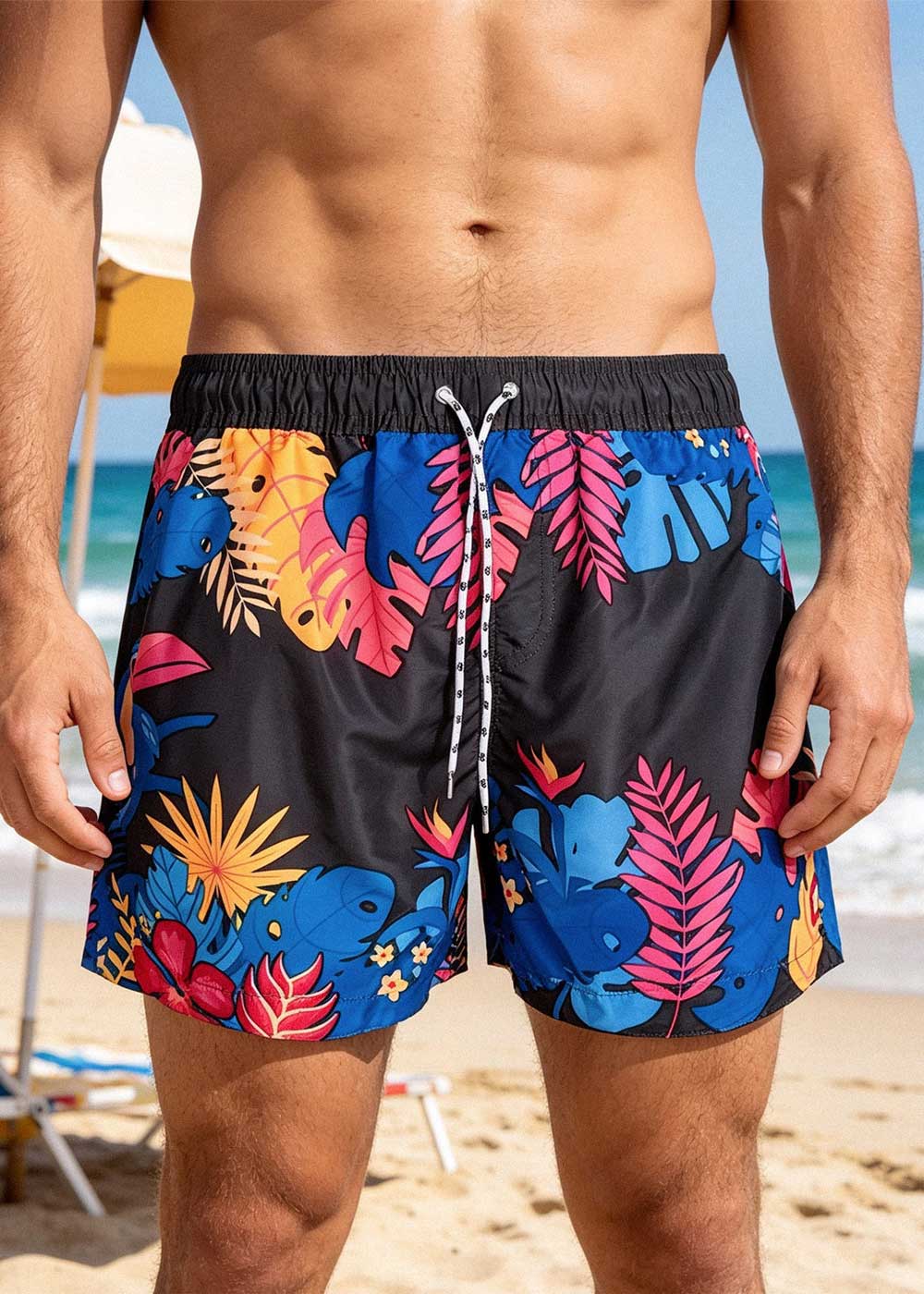 Front view of a man wearing colourful tropical-print men's swim shorts on a sunny beach