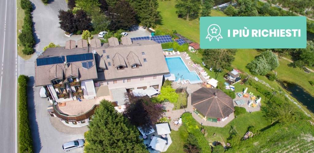 Aerial view of a countryside hotel with outdoor swimming pool, gazebo, solar panels and lawns