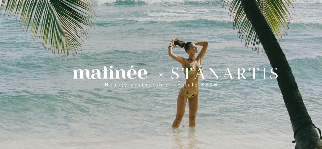 Woman in bikini standing in shallow turquoise sea framed by palm trees, with 'matinée × STANARTIS' branding overlay