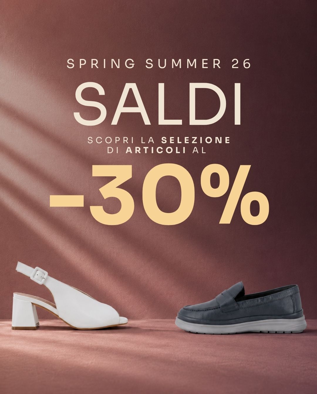 Spring Summer '26 sale poster in Italian showing “SALDI -30%” with a white women’s sandal and a grey men’s loafer on a mauve background