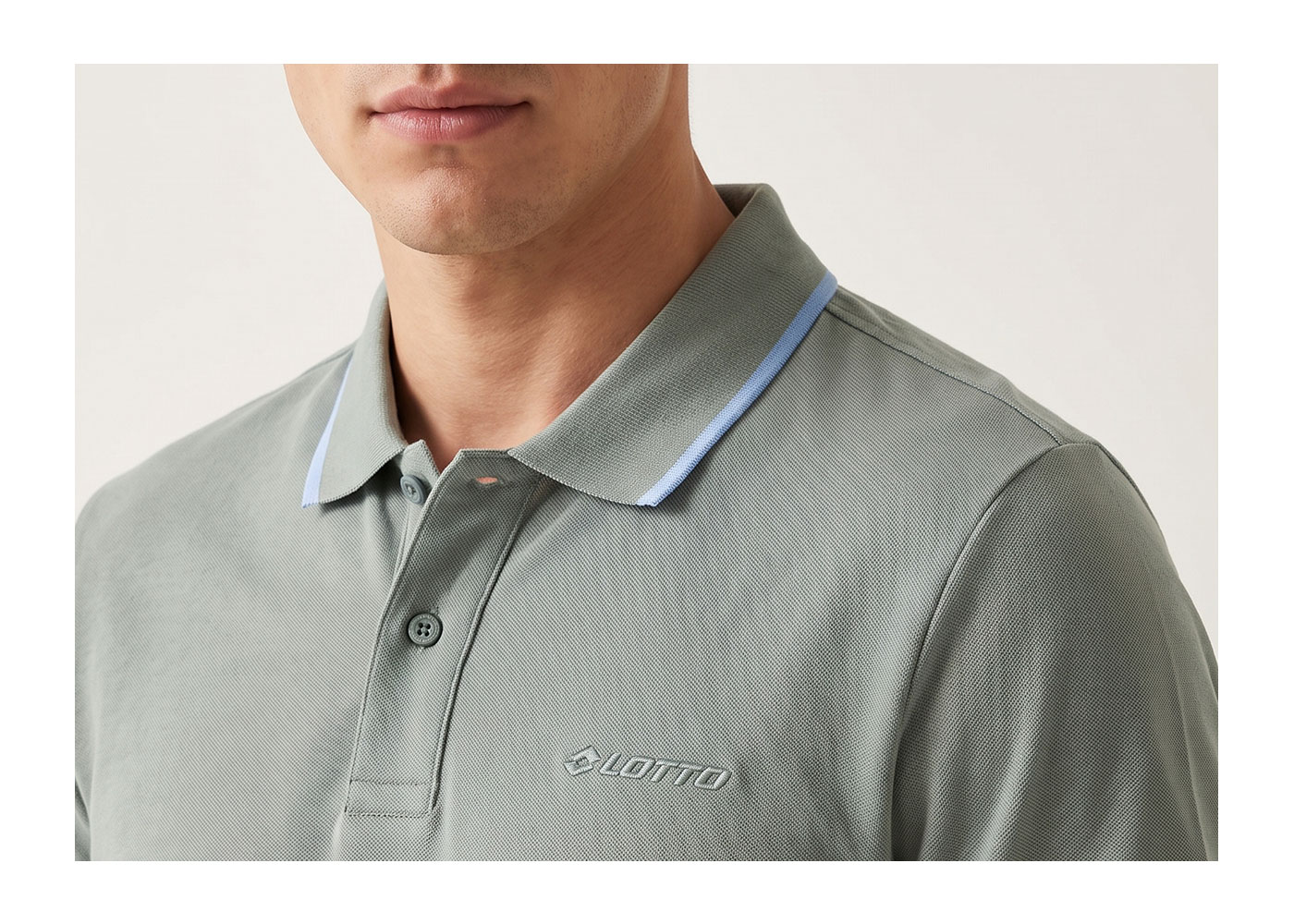Men's sage green polo shirt with light-blue piped collar and embroidered Lotto logo, close-up of chest and neckline
